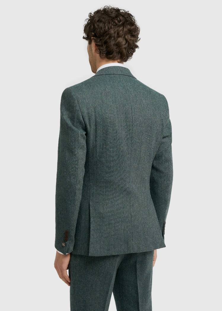 Man wearing a teal green suit jacket on a light gray background
