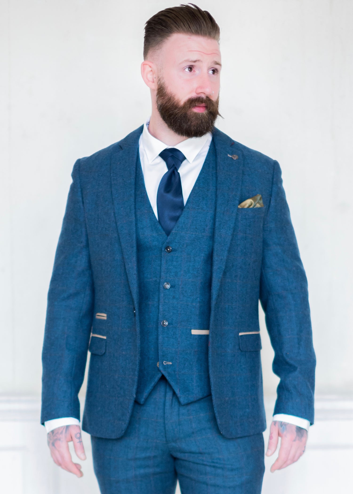 Marc Darcy Dion Tweed Jacket styled with matching waistcoat and trousers. Tattooed model also wearing tie to compliment the suit and a crisp white shirt.