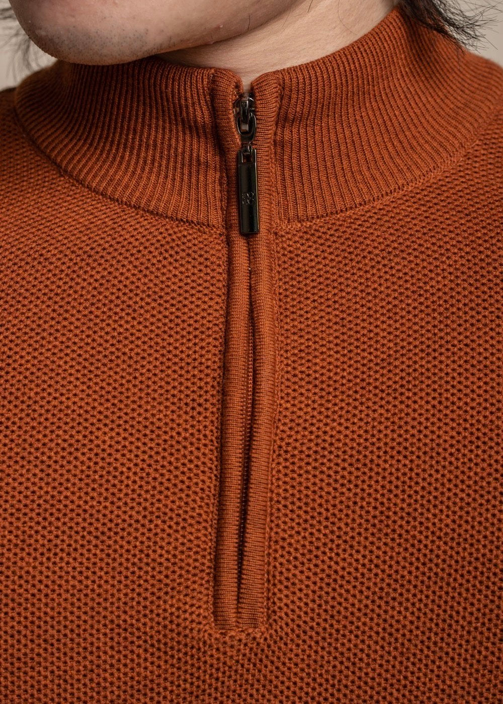 Half zip men's jumper in amber colour, showing details.