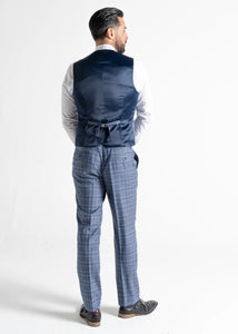 Model wearing Kensington Light-Blue Waistcoat and Trousers has back to the camera, showing reverse details of waistcoat and trousers. 