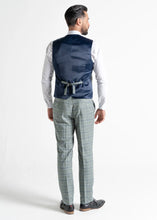 Load image into Gallery viewer, Model wearing Kensington Olive Waistcoat and Trousers has back to the camera, showing reverse details of the waistcoat and trousers.
