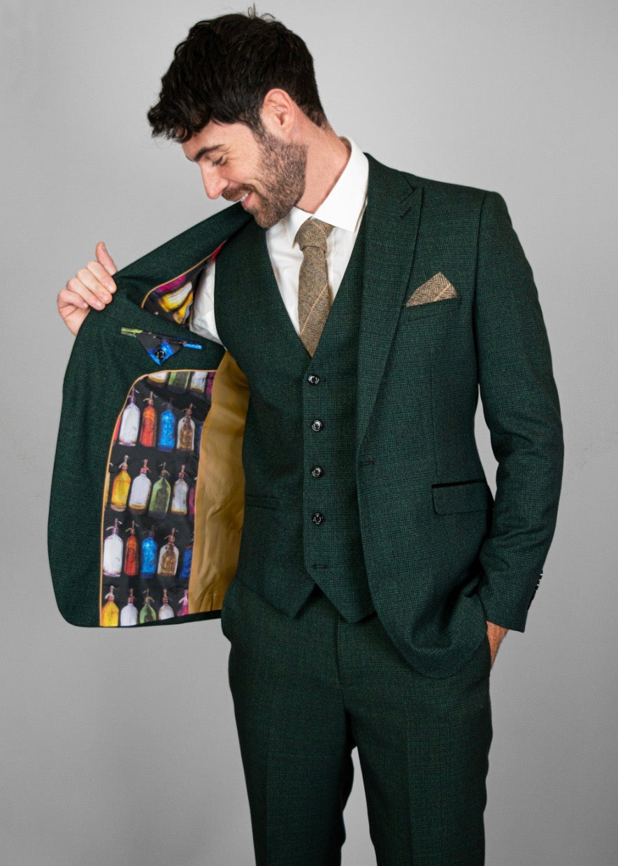 Model wearing full three-piece Caridi while holding open jacket, allowing a look at the inner lining pattern.
